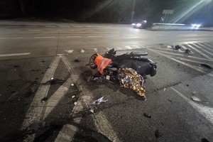 Na zdjęciu widać uszkodzony motocykl, drogę i przejeżdżające pojazdy.