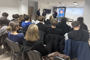 Na zdjęciu widać policjantów, przedstawicielkę sanepidu oraz zgromadzonych uczniów.