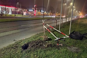 Na zdjęciu widać miejsce zdarzenia drogowego, bariery drogowe. W tle widać przejście dla pieszych i przejazd dla rowerzystów.
