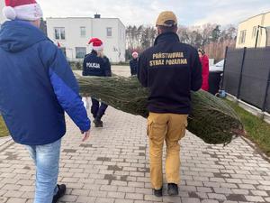 Na zdjęciu widać policjantów oraz inne osoby podczas akcji pomocowej.