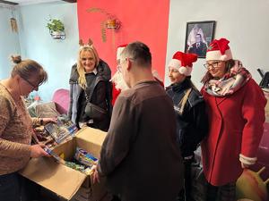 Na zdjęciu widać policjantów oraz inne osoby podczas akcji pomocowej.