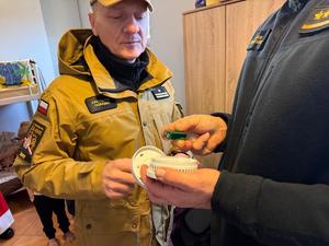 Na zdjęciu widać policjantów oraz inne osoby podczas akcji pomocowej.