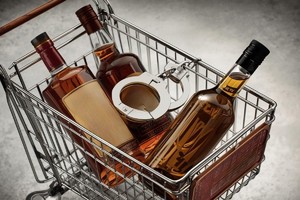 Na grafice widać koszyk z butelkami z alkoholem oraz kajdanki.