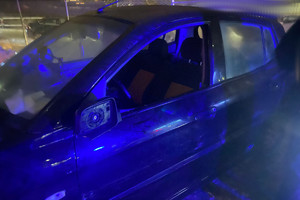 Na zdjęciu widać ciemny samochód z wybitą przednią szybą i uszkodzonym lusterkiem.