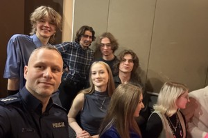 Na zdjęciu widać policjanta oraz uczniów w sali kina.