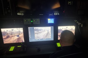 Na zdjęciu widać policjanta siedzącego w RSD przed monitorami, na których widać drogę.