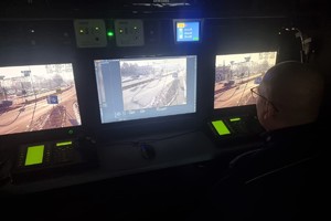Na zdjęciu widać policjanta siedzącego w RSD przed monitorami, na których widać drogę.