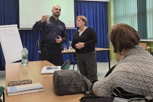 Na zdjęciu widać policjanta oraz nauczycieli podczas spotkania.