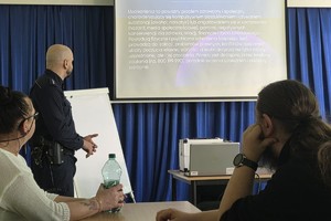Na zdjęciu widać policjanta oraz nauczycieli podczas spotkania.