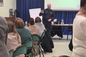 Na zdjęciu widać policjanta oraz nauczycieli podczas spotkania.