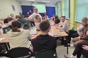 Na zdjęciu widać policjanta oraz nauczycieli podczas spotkania.