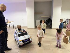 Na zdjęciu widać policjantów oraz przedszkolaków wraz z ich opiekunkami.