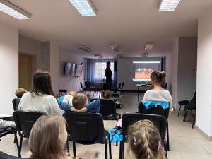 Na zdjęciu widać policjantów oraz przedszkolaków wraz z ich opiekunkami.