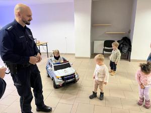 Na zdjęciu widać policjantów oraz przedszkolaków wraz z ich opiekunkami.