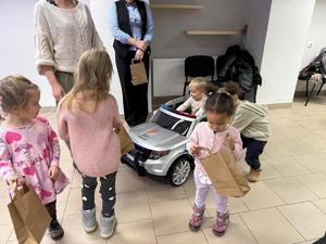 Na zdjęciu widać policjantów oraz przedszkolaków wraz z ich opiekunkami.