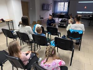 Na zdjęciu widać policjantów oraz przedszkolaków wraz z ich opiekunkami.