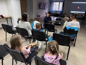 Na zdjęciu widać policjantów oraz przedszkolaków wraz z ich opiekunkami.