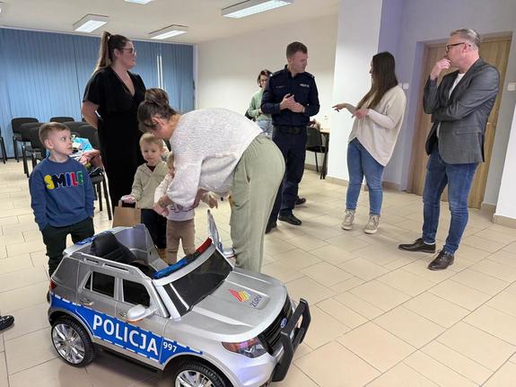 Na zdjęciu widać policjantów oraz przedszkolaków wraz z ich opiekunkami.