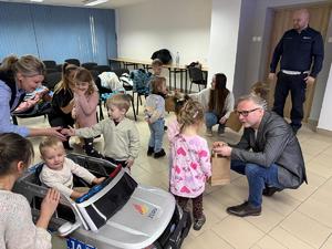 Na zdjęciu widać policjantów oraz przedszkolaków wraz z ich opiekunkami.