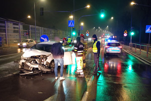 Na zdjęciu widać miejsce zdarzenia drogowego, uszkodzone pojazdy i pracujące służby ratunkowe.