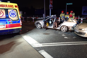 Na zdjęciu widać miejsce zdarzenia drogowego, uszkodzone pojazdy i pracujące służby ratunkowe.