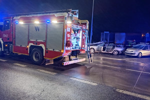 Na zdjęciu widać miejsce zdarzenia drogowego, uszkodzone pojazdy i pracujące służby ratunkowe.
