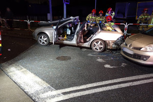 Na zdjęciu widać miejsce zdarzenia drogowego, uszkodzone pojazdy i pracujące służby ratunkowe.