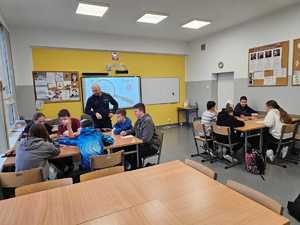 Na zdjęciu widać policjanta oraz uczniów podczas zajęć.