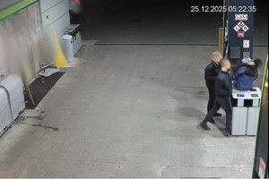 Na zdjęciu widać mężczyzn na stacji paliw w rejonie dystrybutora.