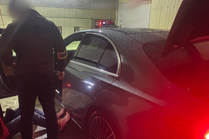 Na zdjęciu widać policjantów oraz szary samochód.