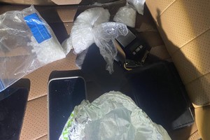 Na zdjęciu widać przedmioty na siedzeniu, w tym woreczki z zawartością białej substancji.