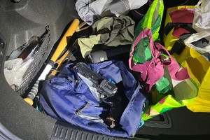 Na zdjęciu widać zawartość bagażnika, w tym przedmiot przypominający broń oraz kij baseballowy.