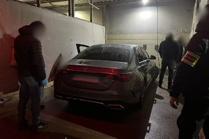 Na zdjęciu widać policjantów oraz szary samochód.