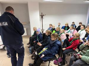 Na zdjęciu widać policjantów, zuchów i ich opiekunów podczas zwiedzania żorskiej komendy Policji.
