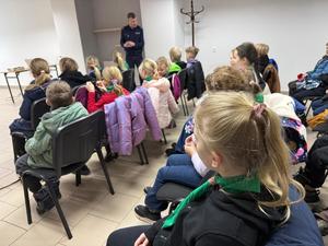 Na zdjęciu widać policjantów, zuchów i ich opiekunów podczas zwiedzania żorskiej komendy Policji.