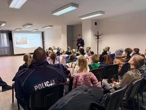 Na zdjęciu widać policjantów, zuchów i ich opiekunów podczas zwiedzania żorskiej komendy Policji.
