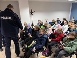 Na zdjęciu widać policjantów, zuchów i ich opiekunów podczas zwiedzania żorskiej komendy Policji.