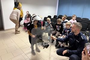 Na zdjęciu widać policjanta oraz przedszkolaki w trakcie profilaktycznych zajęć.