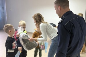 Na zdjęciu widać policjanta oraz przedszkolaki w trakcie profilaktycznych zajęć.