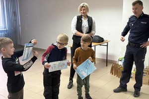 Na zdjęciu widać policjanta oraz przedszkolaki w trakcie profilaktycznych zajęć.