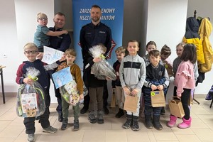 Na zdjęciu widać policjanta oraz przedszkolaki w trakcie profilaktycznych zajęć.