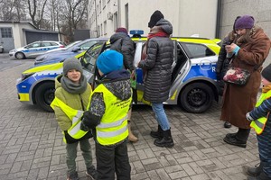 Na zdjęciu widać policjanta oraz przedszkolaki w trakcie profilaktycznych zajęć.