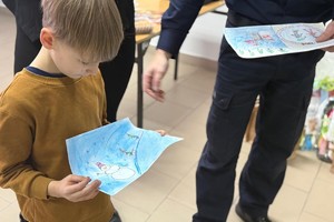 Na zdjęciu widać policjanta oraz przedszkolaki w trakcie profilaktycznych zajęć.