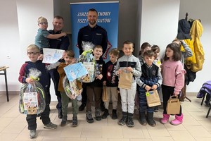 Na zdjęciu widać policjanta oraz przedszkolaki w trakcie profilaktycznych zajęć.