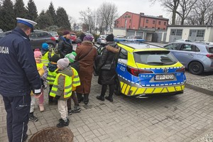 Na zdjęciu widać policjanta oraz przedszkolaki w trakcie profilaktycznych zajęć.