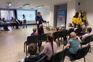 Na zdjęciu widać policjanta oraz przedszkolaki w trakcie profilaktycznych zajęć.