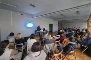 Na zdjęciu widać policjanta i nauczycieli podczas spotkania.