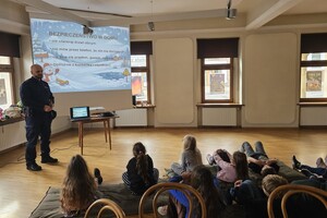 Na zdjęciu widać policjanta oraz uczestników półkolonii.