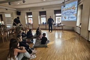 Na zdjęciu widać policjanta oraz uczestników półkolonii.