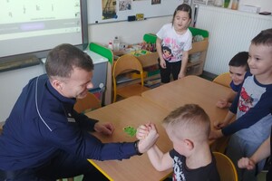 Na zdjęciu widać policjantów i dzieci.